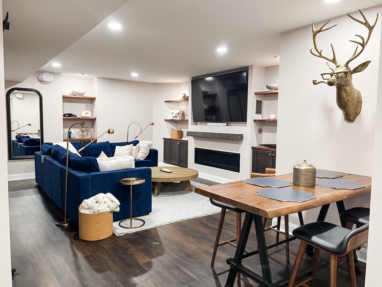 Finished basement living area with built-in shelving, sectional seating, and wood flooring 6